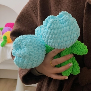 Handgefertigter gehäkelter Tulpenstrauß aus blauem und grünem Garn in der Hand