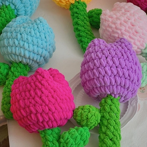 Nahaufnahme handgemachter Häkel-Tulpen in verschiedenen Farben mit Strickgarn-Textur