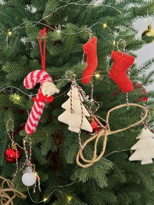 Detail of velvet Christmas stockings and bear candy cane ornaments on a warm lighted tree