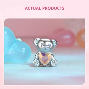 Vista detallada del dije de oso de plata con corazón de cristal de opale y ojos de diamante