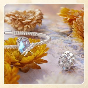 Detailed macro view of S925 sterling silver dragonfly charms with blue stone on a bracelet