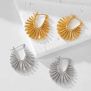 Detailed view of fan-shaped metallic earrings with radial stripes in gold and silver