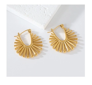 Detail view of golden irregular sunburst earrings with a polished finish on stone