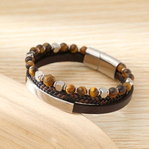 Macro detail of men's tiger eye stone beads and braided leather bracelet with magnetic clasp