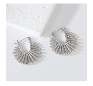 Detailed close-up of geometric fan-shaped silver earrings with radiating striped design