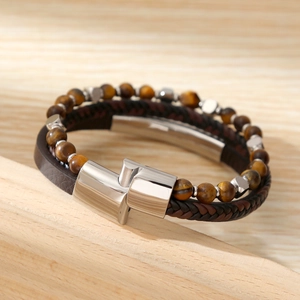 Close-up of multilayer men's bracelet with tiger eye beads and leather on wood tray