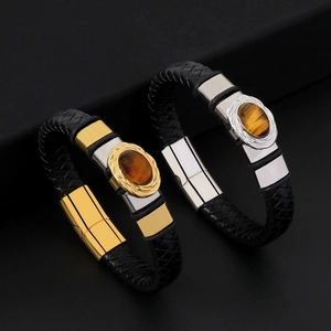 Dettaglio di bracciali in pelle intrecciata con pietra occhio di tigre e chiusura magnetica