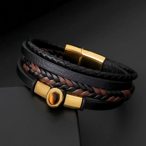 Macro view of men's leather bracelet showing tiger eye stone and gold magnetic clasp
