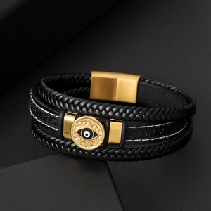 Vue macro d'un bracelet en cuir noir tressé à trois couches avec plaque centrale œil d'or