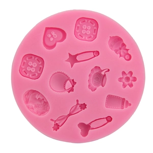 Pink silicone mold featuring buttons, baby icons, and relief portrait for fondant and DIY crafts
