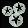 Close-up of three graduated white star-shaped plunger cutters for fondant cake decoration