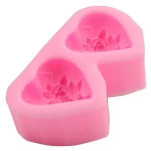 Pink silicone mold featuring two heart cavities with rose flower patterns for cake decorating