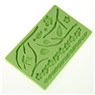 Detail view of green silicone fondant mold with floral leaves and flower textures