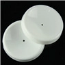 Close-up of two white circular carving tool caps with center holes on black background