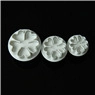 Three sizes of white flower-shaped fondant cake cutters in a row on black background