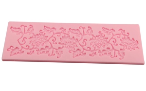Detail of pink silicone lace mold with floral vine patterns for fondant cake decoration