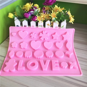 Pink silicone baking mold with heart, star and LOVE shapes on wooden surface