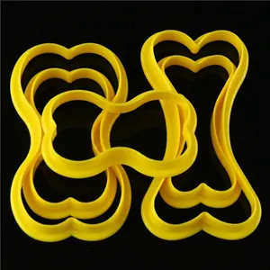 Set of bright yellow bone-shaped plastic cookie cutters for baking in various sizes