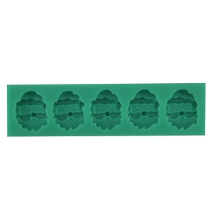 Detailed view of green silicone mold featuring five Santa Claus head shapes for cake decorating