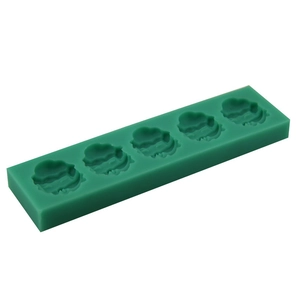 Macro shot of dark green silicone mold with five cloud-shaped cavities for DIY baking