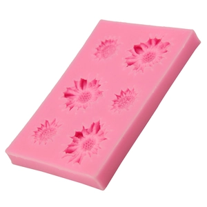 Pink silicone fondant cake mold with six sunflower patterns on a white background