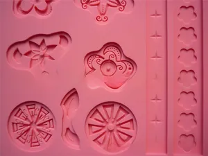 Macro shot of pink silicone fondant mold with detailed flower and star embossed patterns