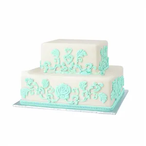 Close-up of mint green rose fondant embossing on a white two-tier square cake