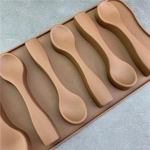 Brown 6-cavity silicone spoon mold for DIY chocolate baking with matte finish on stone background