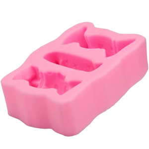 Macro detail of a pink silicone mold showing three candy-shaped cavities for DIY baking