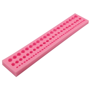 Pink silicone mold featuring three rows of pearl chain shapes for DIY cake decorating and baking
