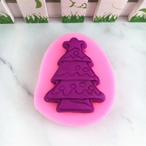 Close-up of pink Christmas tree silicone mold with purple resin craft on marble background