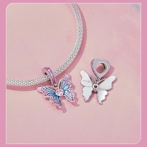 Macro detail of S925 sterling silver butterfly charm with pink enamel and heart gemstone