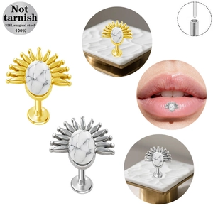 Dettaglio del piercing labret in acciaio 316L con design a raggiera e pietra marmorea