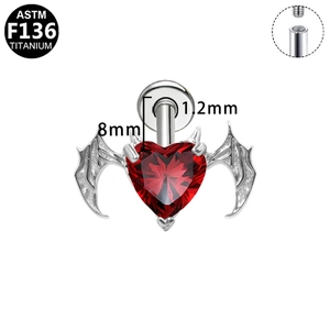 Macro detail of G23 titanium gothic heart stud with bat wings and red gem
