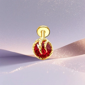 Macro shot of gold dragon claw holding a faceted red gem on a sparkling background