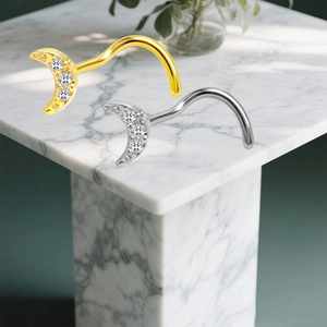 Nahaufnahme von Titan-Nasensteckern in Mondform mit Zirkonia in Gold und Silber