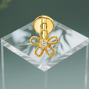 Macro-opname van G23 titanium gouden bloem oorknopje met zirkonia en gedraaide textuur