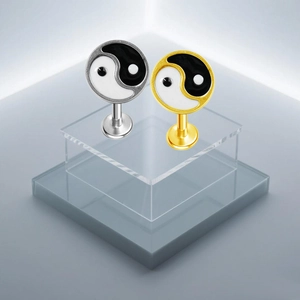 Dettaglio di piercing labret in acciaio inossidabile con motivo Yin Yang smaltato bianco e nero