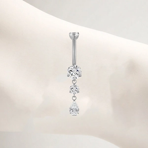 Detail view of titanium belly ring featuring triple clear zircon and a pear-shaped drop
