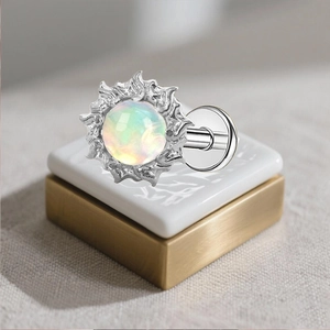 Macro view of G23 titanium stud featuring a sunburst frame with a rainbow opal center