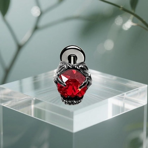 Detail shot of red zircon heart stud with dark metal claw setting on acrylic block