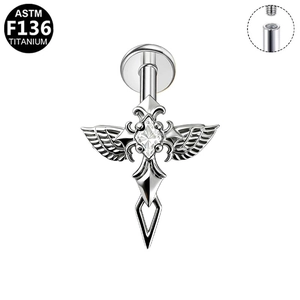 Close-up of ASTM F136 titanium winged cross piercing with internal thread detail