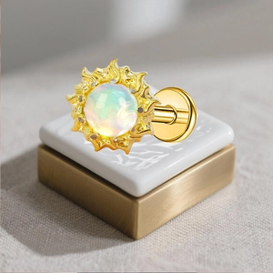 Macro shot of G23 titanium sun-shaped labret stud with a colorful fire opal stone inlay