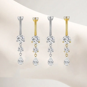 Detail of titanium belly rings with triple round stones and teardrop zircon pendants