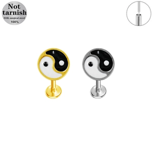 Dettaglio dei piercing labret Yin-Yang in oro e argento realizzati in acciaio chirurgico