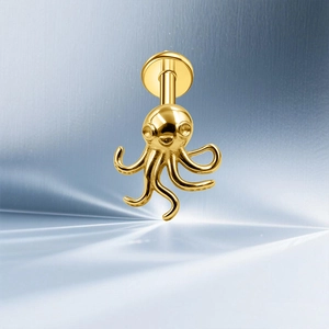 Macro-opname van een gepolijste gouden octopus piercing met platte schroefsluiting