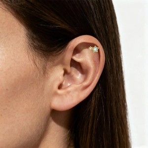Detail of G23 titanium star ear stud with blue opal and zircon on model ear
