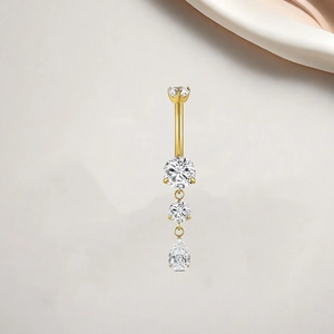 Macro shot of gold-plated titanium navel ring with teardrop and round zircon stones