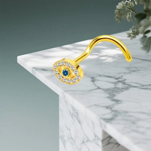 Detailaufnahme eines goldenen L-förmigen Nasensteckers mit blauem Zirkonia-Auge