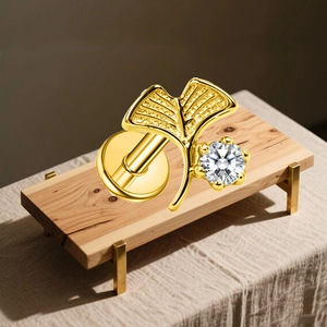 Macro detail of gold G23 titanium gingko leaf earring with cubic zirconia and flat back